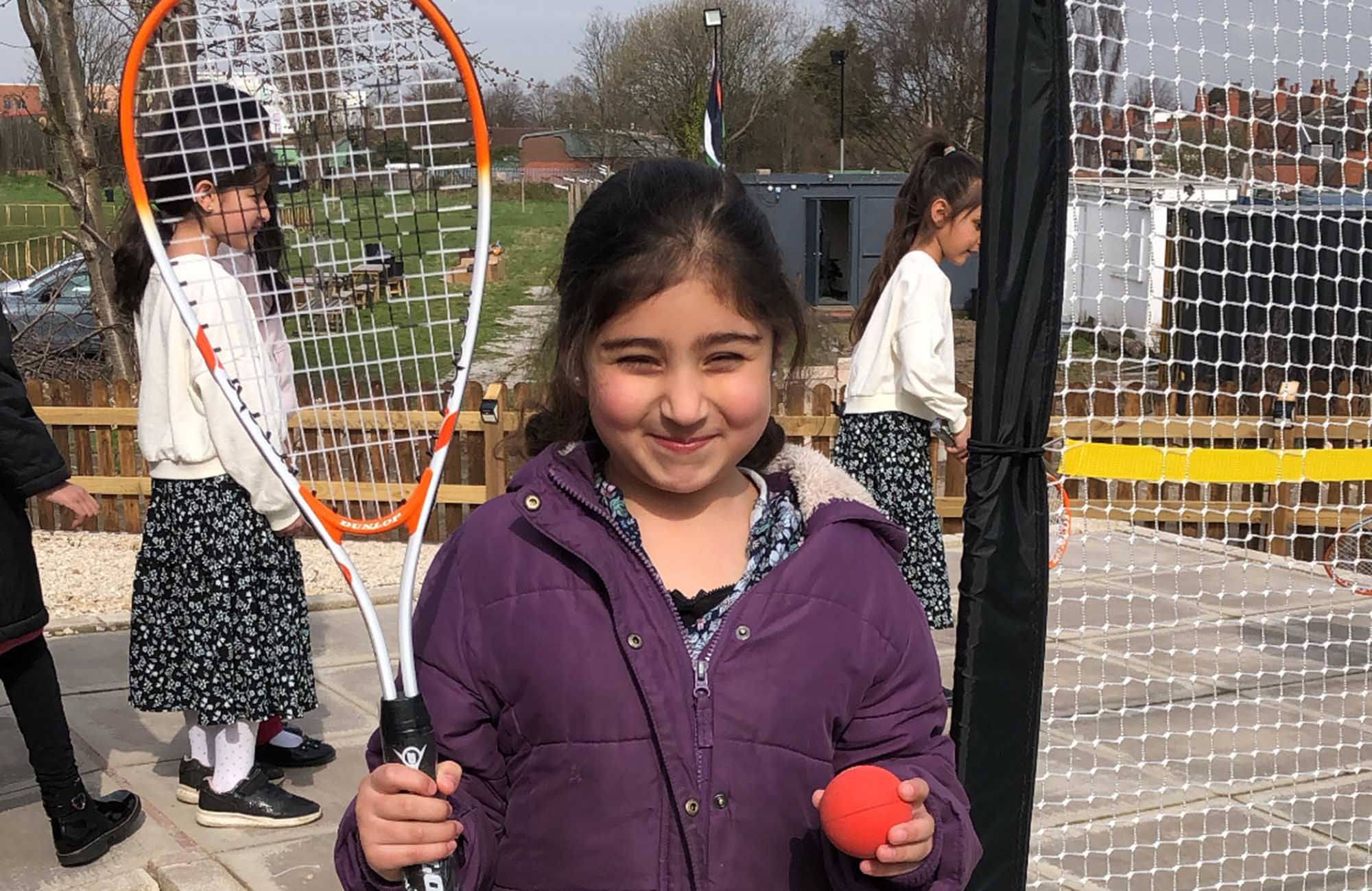 Child squash player with orange Dunlop mini squash ball