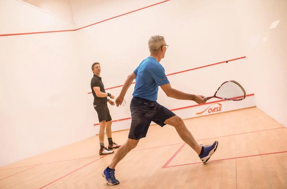 The photo shows two players having a game of squash