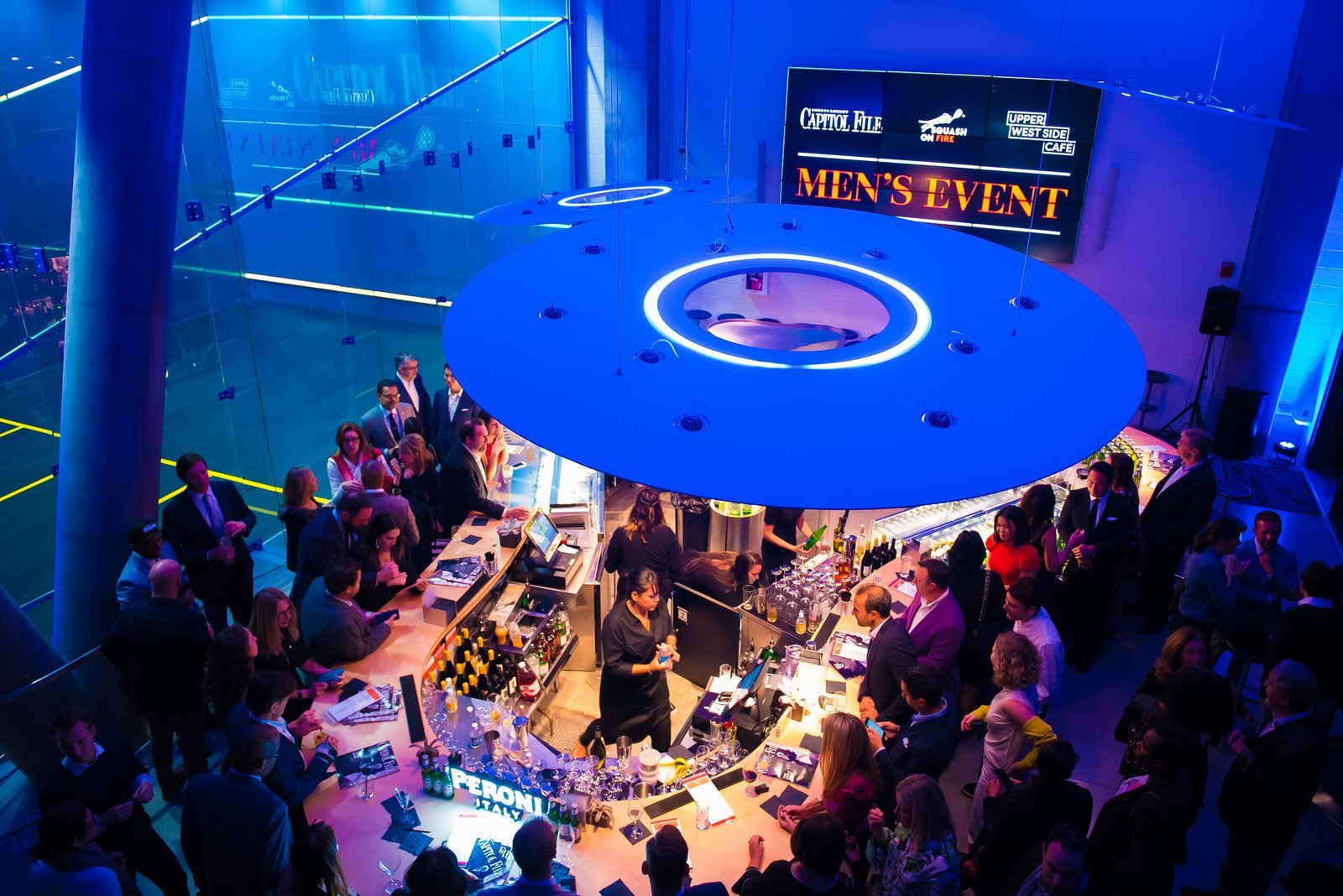 The photo shows a packed bar, the social meeting point of the Squash on Fire