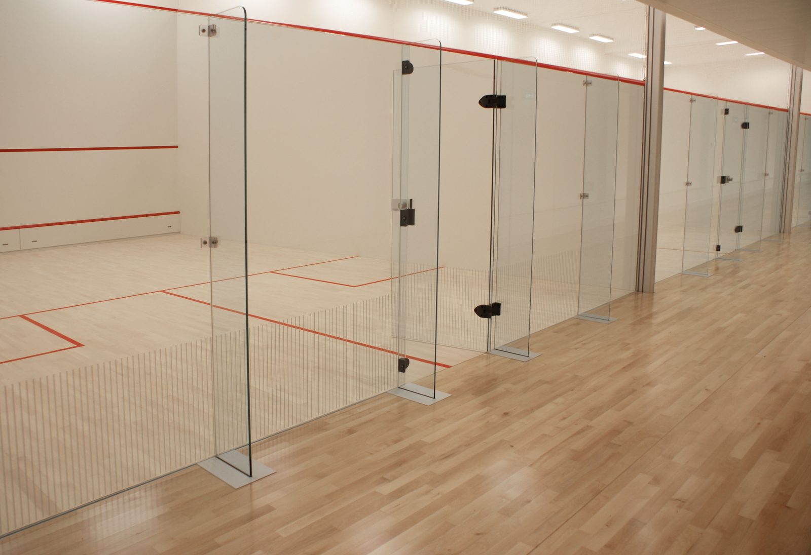 a row of squash courts with fin glass back walls