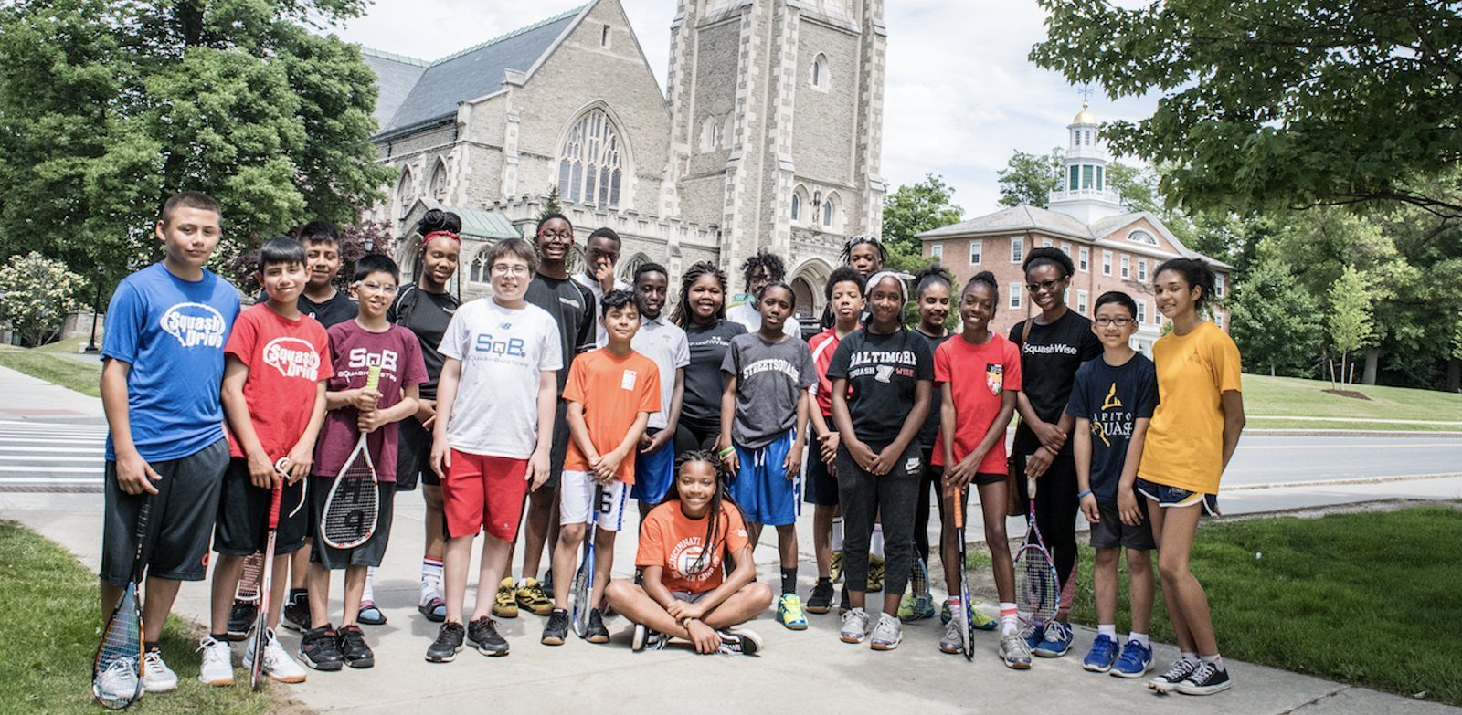 Kids with squash rackets in front of a church