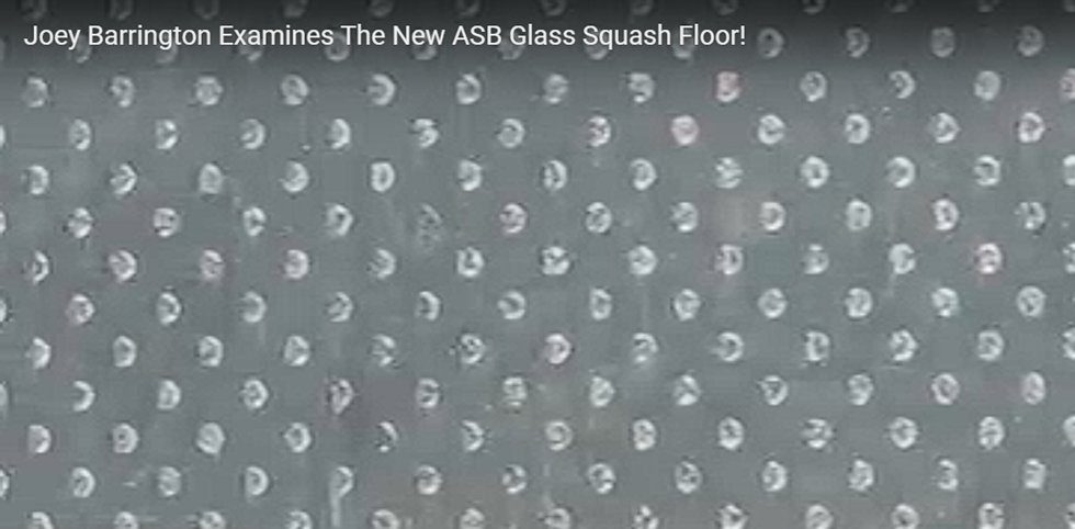 Close-up of the ASB GlassFloor surface showing the raised ceramic dots engineered to provide traction. These micro-features are designed to interrupt sweat films and improve grip, but their long-term resistance to wear and micro-abrasion remains debated in the squash community.