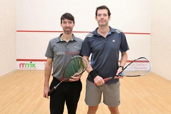 The image features Jonathan Gallacher (on the right) and British coach Hadrian Stiff, posing together on a squash court.